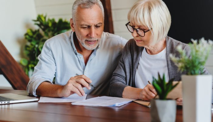 Mature couple with financial documents in home interior